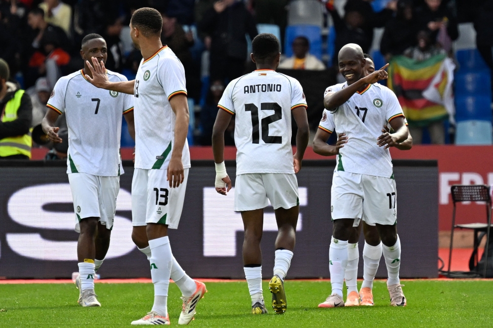 Zimbabwe's forward #17 Knowledge Musona (R) celebrates scoring the team's first goal during the Africa Cup of Nations (AFCON) Group B football match between Angola and Zimbabwe at Marrakesh Stadium in Marrakesh on December 26, 2025. (Photo by Khaled Desouki / AFP)