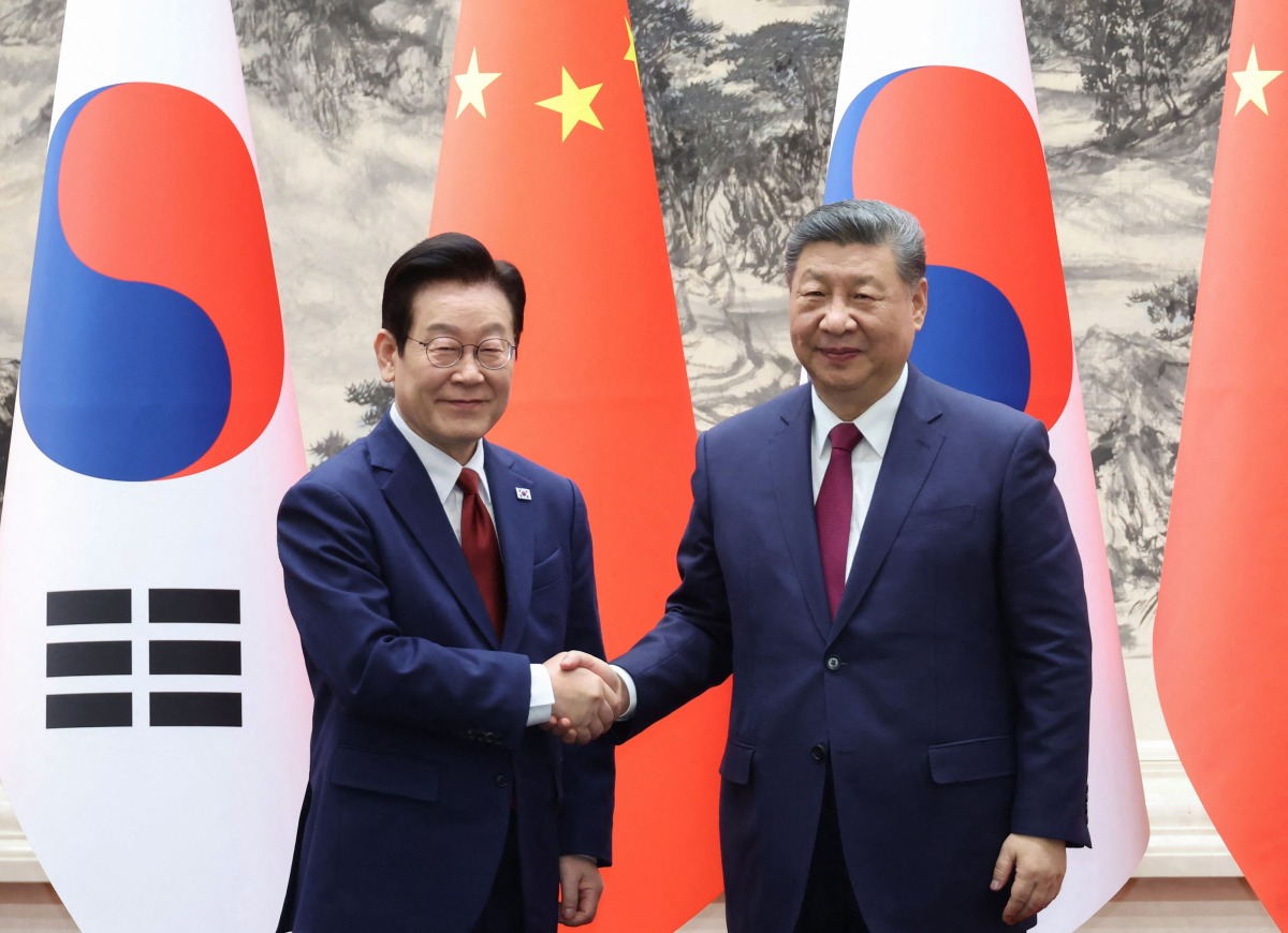 South Korea's President Lee Jae Myung (L) shakes hands with China's President Xi Jinping (R) during a Memorandum of Understanding (MOU) signing ceremony at the Great Hall of the People in Beijing on January 5, 2026. Photo by YONHAP / AFP
