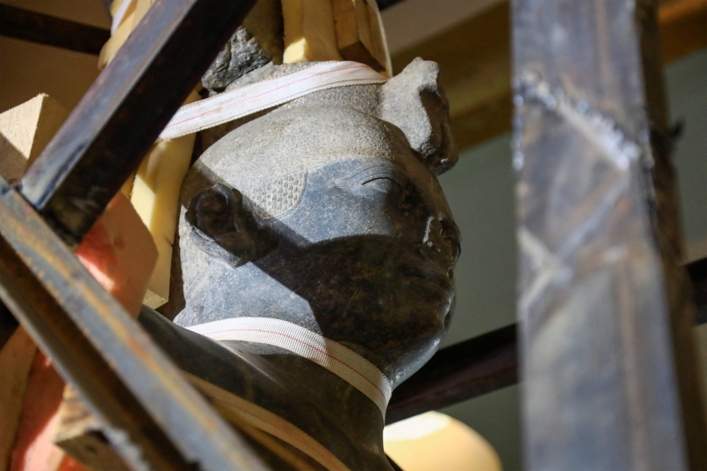 A picture shows a view of the 7th century BC King Taharqa of the 25th Kushite empire dynasty as workers move it from the entrance of the Sudan National Museum to a new location within, during an official ceremony as part of the museum's ongoing renovations in Khartoum on January 14, 2023.
