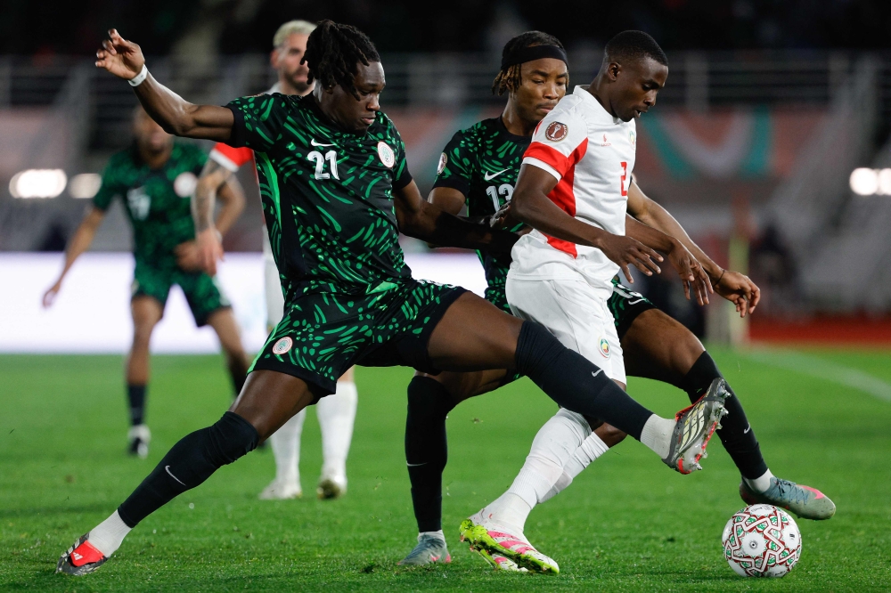 Nigeria's defender #21 Calvin Bassey (L) and Nigeria's forward #12 Cyriel Dessers close in on Mozambique's defender #02 Infren Matola during the Africa Cup of Nations (CAN) round of 16 football match between Nigeria and Mozambique at the Sports Complex stadium in Fes on January 5, 2026. (Photo by Abdel Majid Bziouat / AFP)