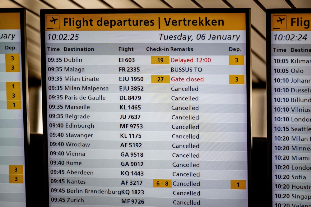 This photograph shows a flight departures information board displaying numerous cancellations at the Schiphol Airport on January 6, 2026 as hundreds of flights have been cancelled again at the airport due to snowfall. (Photo by Robin Utrecht / ANP / AFP) / Netherlands OUT