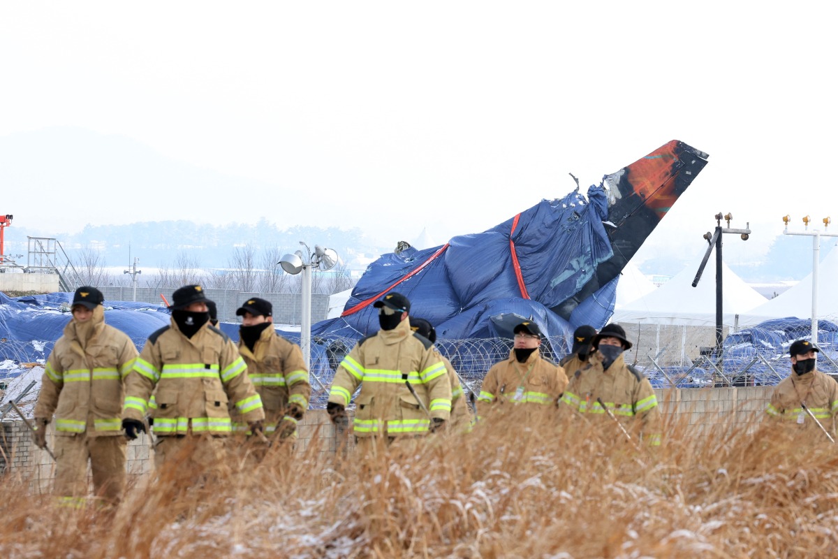 Firefighters take part in a search operation near the site where a Jeju Air Boeing 737-800 aircraft crashed and burst into flames at Muan International Airport in Muan, some 288 kilometres southwest of Seoul on January 11, 2025. Photo by YONHAP / AFP

