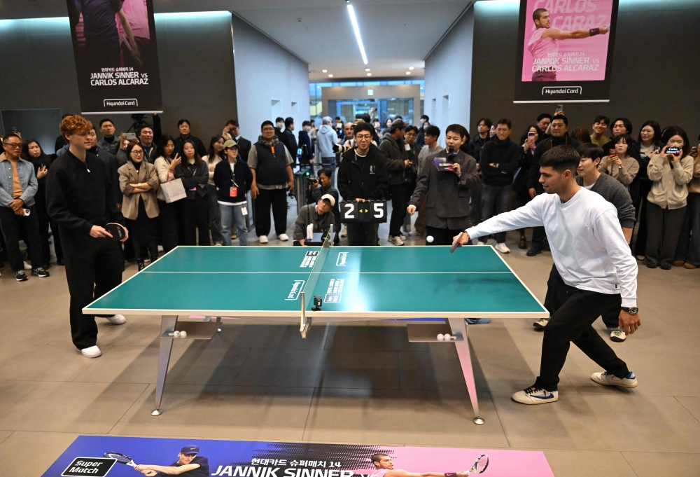 Italy's Jannik Sinner (L) plays table tennis with Spain's Carlos Alcaraz (R) during a welcome event in Seoul on January 9, 2026, ahead of their tennis exhibition match. (Photo by Jung Yeon-je / AFP)