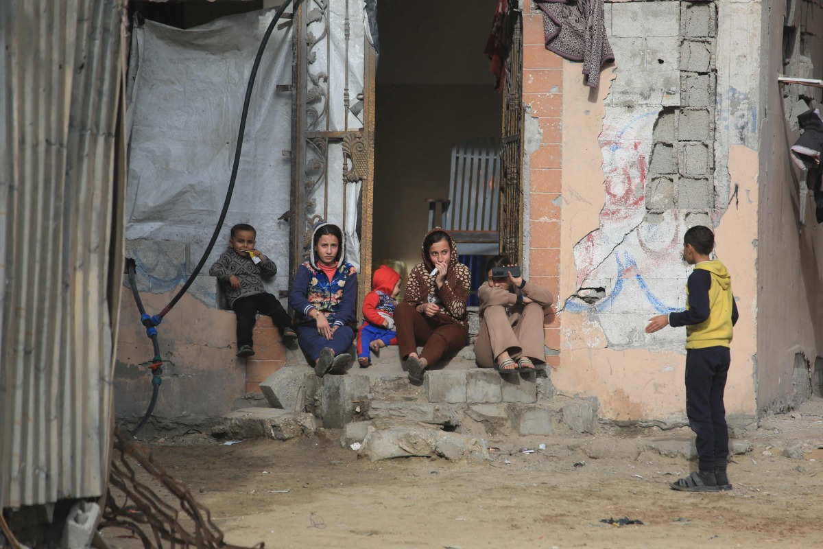 Children sit on doorstep of a damaged building in Jabalia, in the northern Gaza Strip, on January 10, 2026. (Photo by Bashar Taleb / AFP)