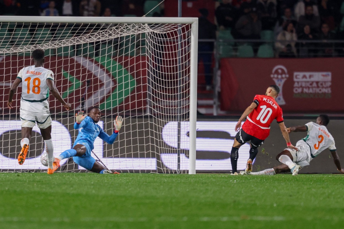 Egypt's forward #10 Mohamed Salah scores a goal in front of Ivory Coast's goalkeeper #01 Yahia Fofana during the Africa Cup of Nations (CAN) quarter-final football match between Egypt and Ivory Coast at the Grand stadium in Agadir on January 10, 2026. (Photo by FRANCK FIFE / AFP)