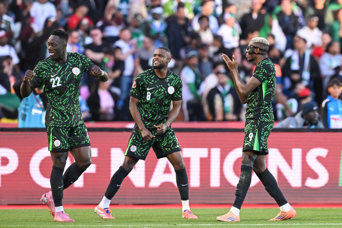 Nigeria's forward #22 Akor Adams and Nigeria's midfielder #08 Frank Onyeka celebrate Nigeria's forward #09 Victor Osimhen 's goal during the Africa Cup of Nations (CAN) quarter-final football match between Algeria and Nigeria at the Grand stadium in Marrakesh on January 10, 2026. (Photo by SEBASTIEN BOZON / AFP)

