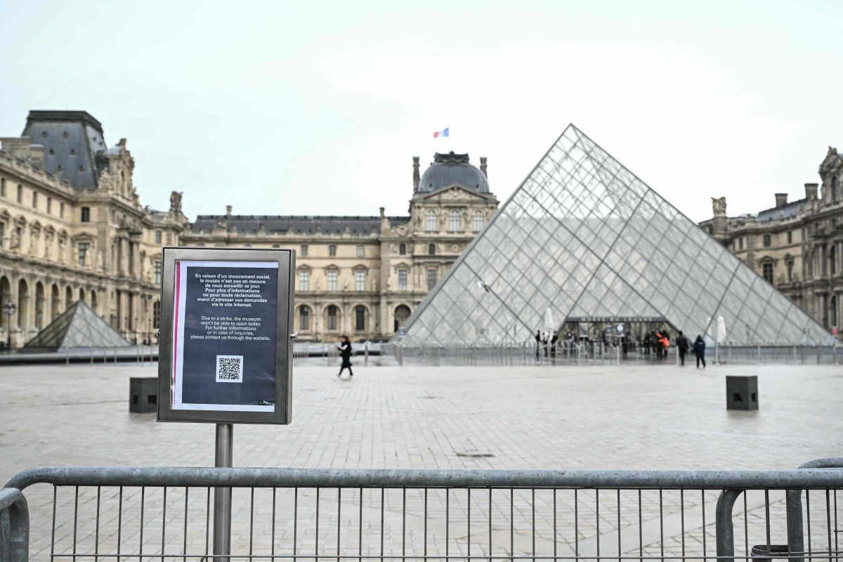 A photo shows an information panel notifying of the closure of the Louvre Museum on the empty plaza with the Louvre Pyramid, designed by Chinese-US architect Ieoh Ming Pei, as the museum is closed due a strike in Paris on January 12, 2026. Photo by Martin LELIEVRE / AFP