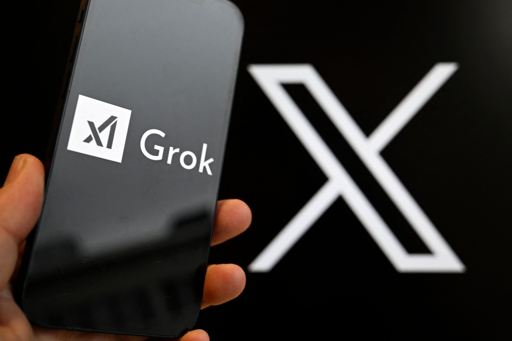 (Files) This photograph shows a smartphone bearing the logo of Grok in Brussels on January 12, 2026. (Photo by Nicolas Tucat / AFP)