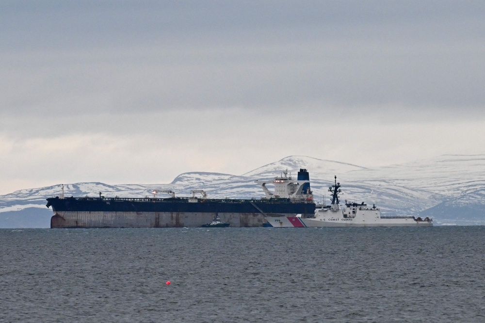 An oil tanker formerly known as the Bella-1, before it changed its name to the Marinera, is pictured alongside a US coast guard ship, at sea in the Moray Firth, northern Scotland, on January 14, 2026. (Photo by Andy Buchanan/ AFP)