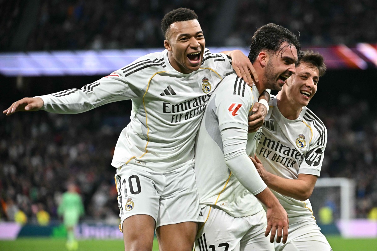 Real Madrid's Spanish defender #17 Raul Asencio (C) celebrates with Real Madrid's French forward #10 Kylian Mbappe (L) and Real Madrid's Turkish midfielder #15 Arda Guler after scoring his team's second goal during the Spanish league football match between Real Madrid CF and Levante UD at Santiago Bernabeu Stadium in Madrid on January 17, 2026. (Photo by Javier SORIANO / AFP)