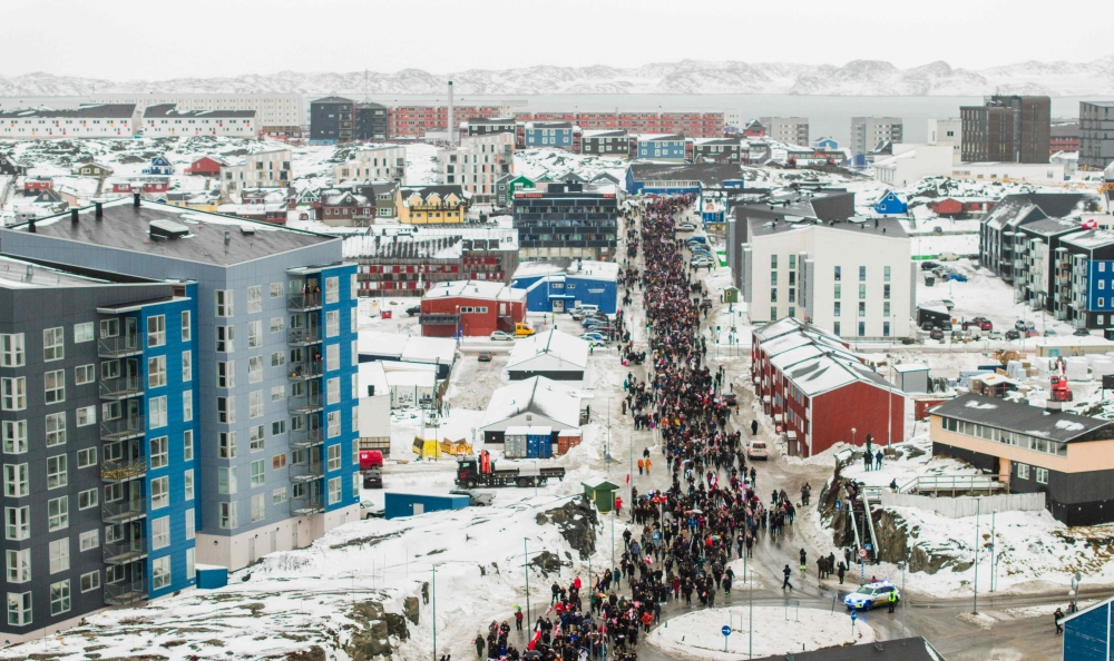 This aerial view taken by Mads Schmidt Rasmussen and handed out by Arctic Creative shows people as they take part in a demonstration to protest against the US President's plans to take Greenland, on January 17, 2026 in Nuuk, Greenland. (Photo by Mads Schmidt Rasmussen / various sources / AFP) 