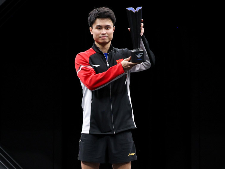Zhou Qihao celebrates with the trophy.
