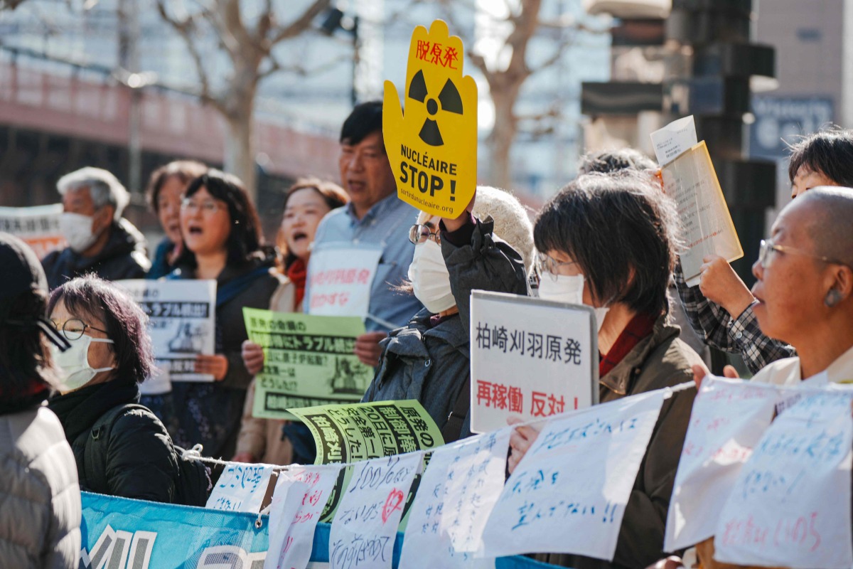 Participants demonstrate in front of Tokyo Electric Power Company's headquarters, against the restart of the Kashiwazaki-Kariwa Nuclear Power Plant, in Tokyo on January 19, 2026. (Photo by Kazuhiro NOGI / AFP)