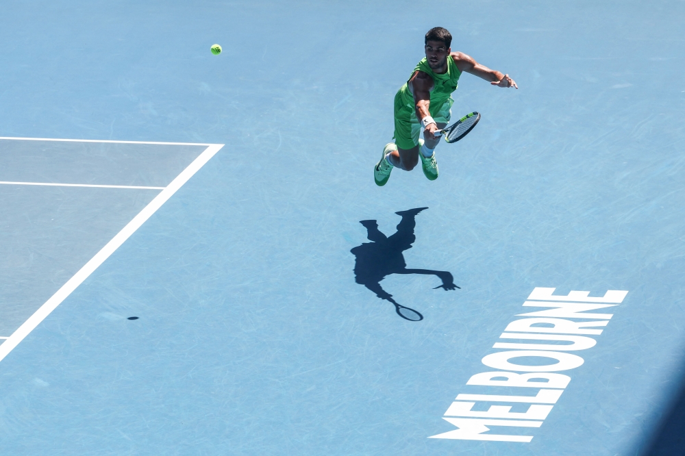Spain's Carlos Alcaraz hits a return against USA's Tommy Paul during their men's singles match on day eight of the Australian Open tennis tournament in Melbourne on January 25, 2026. (Photo by Izhar Khan / AFP)