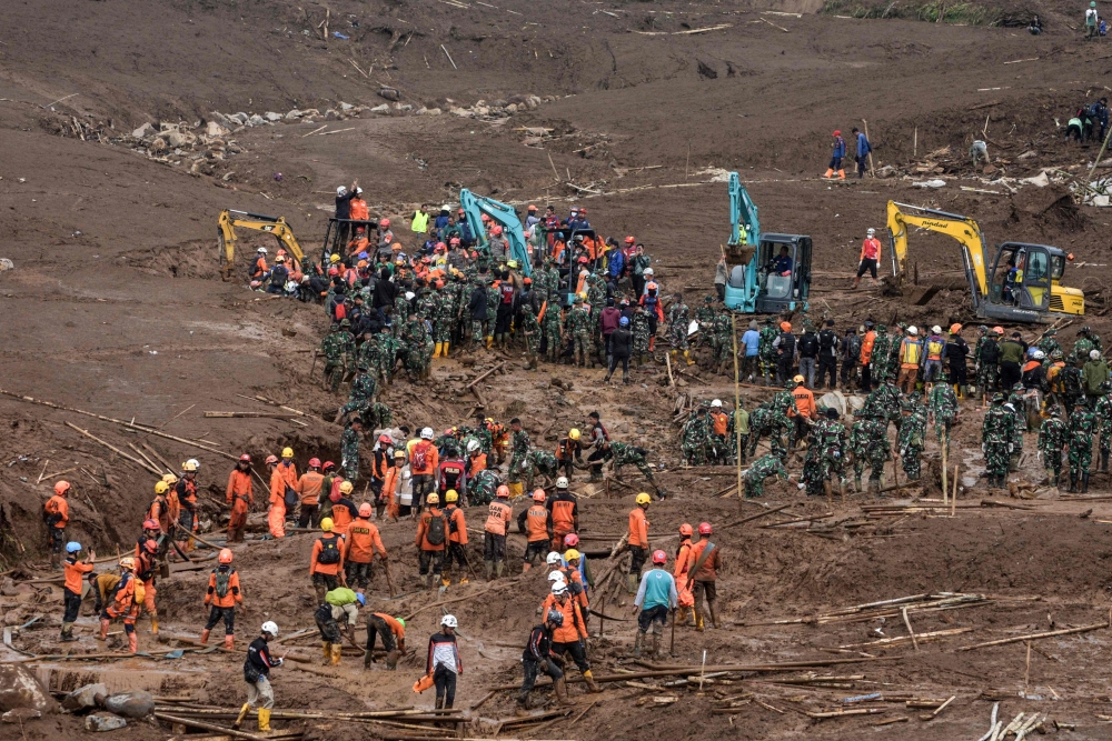 Rescuers search for victims buried by a landslide in Pasirlangu village in Bandung, West Java, on January 26, 2026. (Photo by Timur Matahari / AFP)
