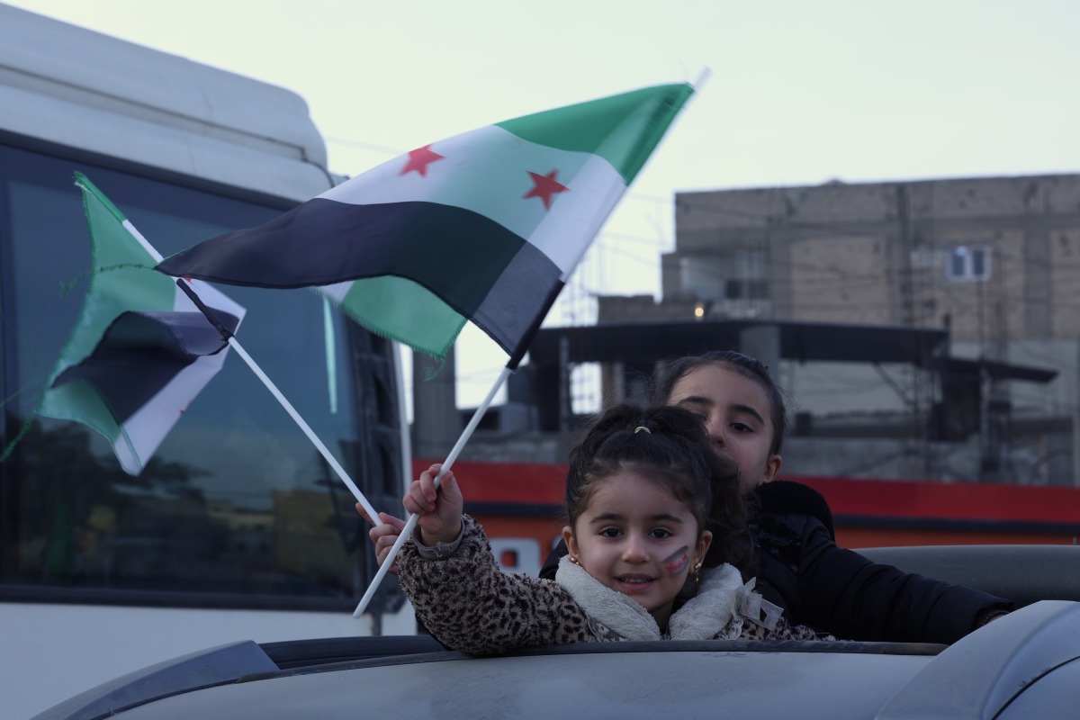 Children wave flags in Raqqa, northern Syria, January 21, 2026. (Str/Xinhua)