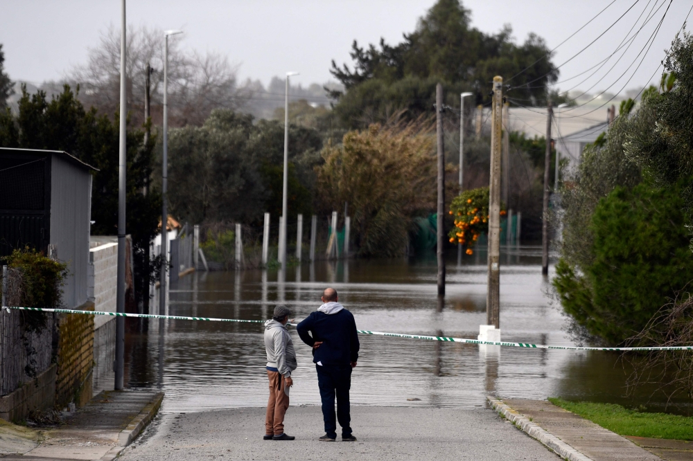 Two people observe a flooded area at Las Pachecas settlement in Jerez, southern Spain, on February 5, 2026, amid Storm Leonardo. (Photo by Cristina Quicler / AFP)