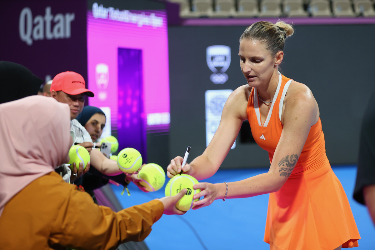 Karolina Pliskova of the Czech Republic signs autographs after the match against Amanda Anisimova of the United States.