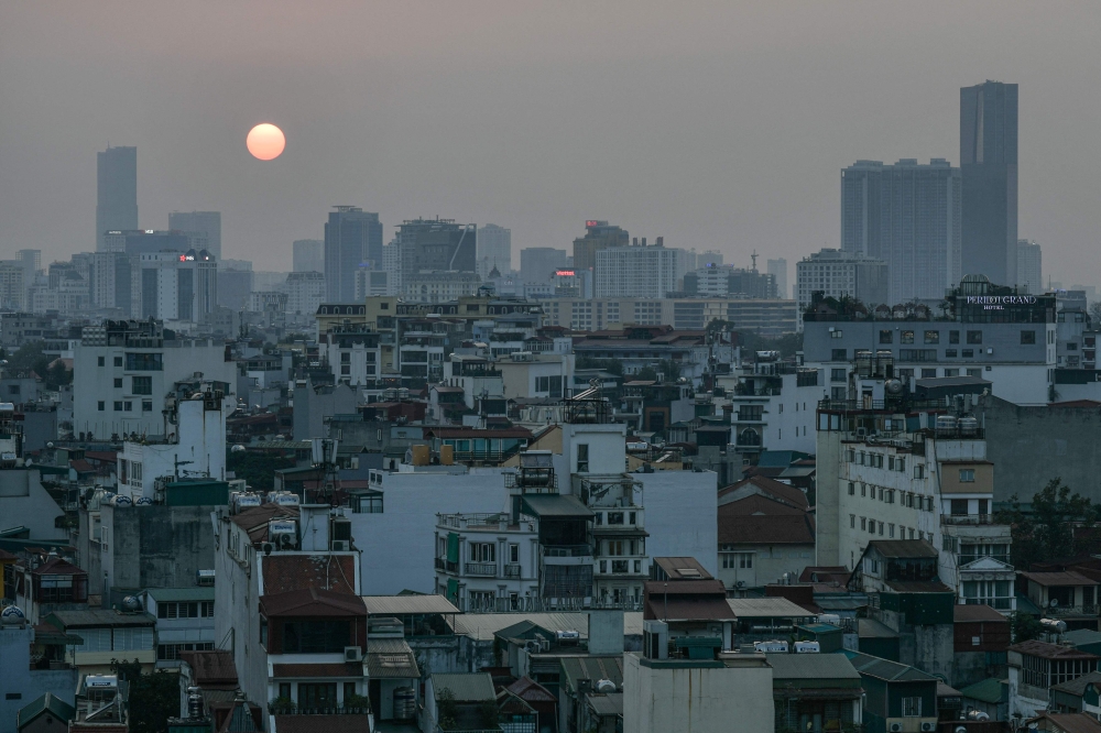 A general view shows the sun setting over the skyline in the old quarter of Hanoi on February 20, 2026. (Photo by Amaury Paul / AFP)