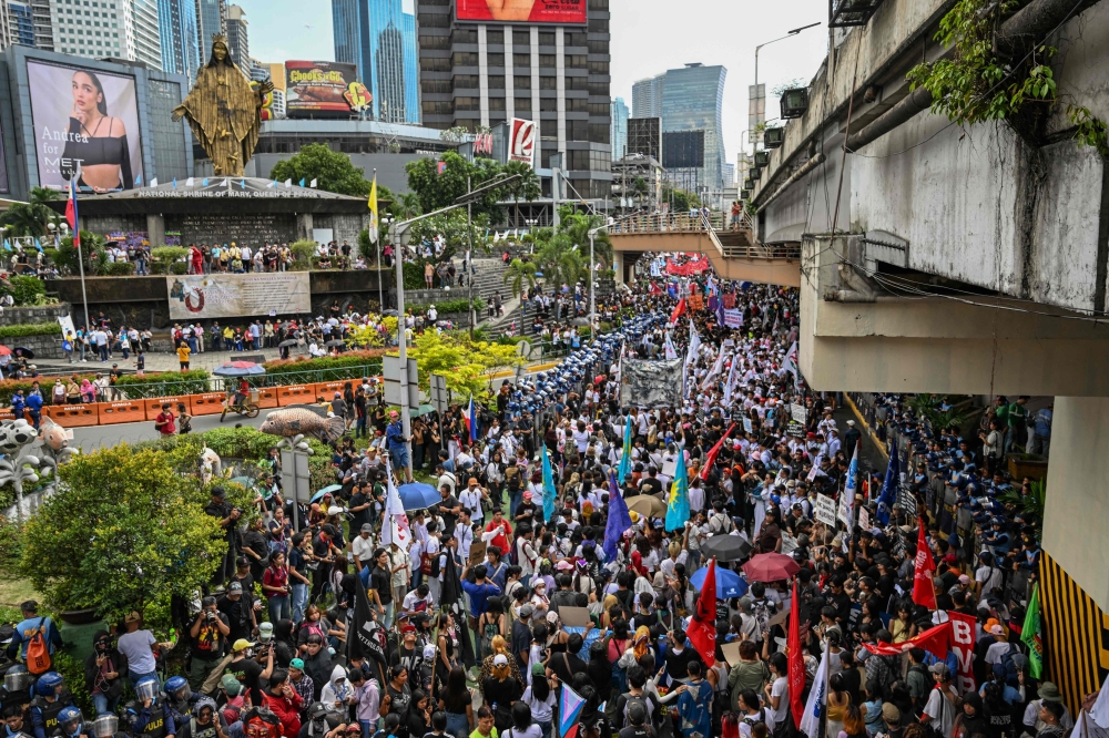 Protesters march during an anti-corruption rally that coincides with the 40th anniversary of the EDSA People Power Revolution, in Quezon City on February 25, 2026. (Photo by Jam Sta Rosa / AFP)
