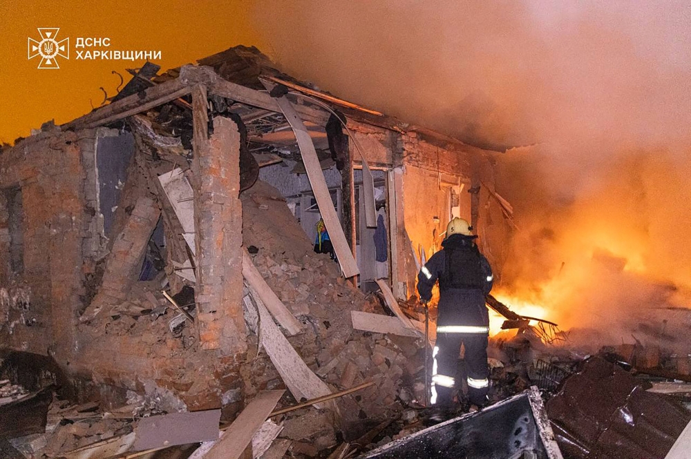 Handout photo by the State Emergency Service of Ukraine shows a firefighter extinguishing a fire in a damaged house following a Russian attack in Kharkiv. (Photo by Handout / State Emergency Service of Ukraine / AFP)
