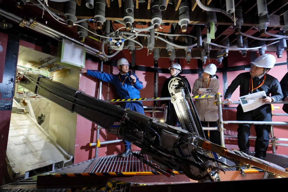 A robotic arm demonstrates the removal of melted nuclear fuel debris during a simulation at the Fukushima Daiichi Nuclear Power Plant on February 25, 2026. (Photo by Japan Pool / JIJI PRESS / AFP) 