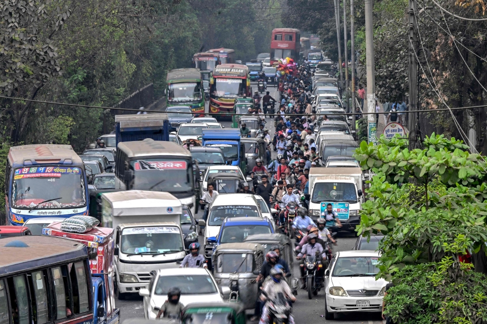 People wait in a queue (R) to refuel their vehicles near a fuel station in Dhaka on March 8, 2026. (Photo by Munir Uz Zaman / AFP)
