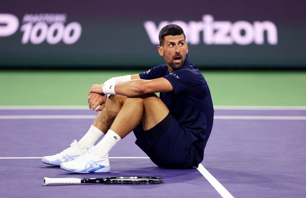 Novak Djokovic of Serbia sits up after falling to the court with exhaustion against Jack Draper of Great Britain in their fourth round match of the BNP Paribas Open at Indian Wells Tennis Garden on March 11, 2026, in Indian Wells, California.  (Photo by CLIVE BRUNSKILL / GETTY IMAGES NORTH AMERICA / Getty Images via AFP)