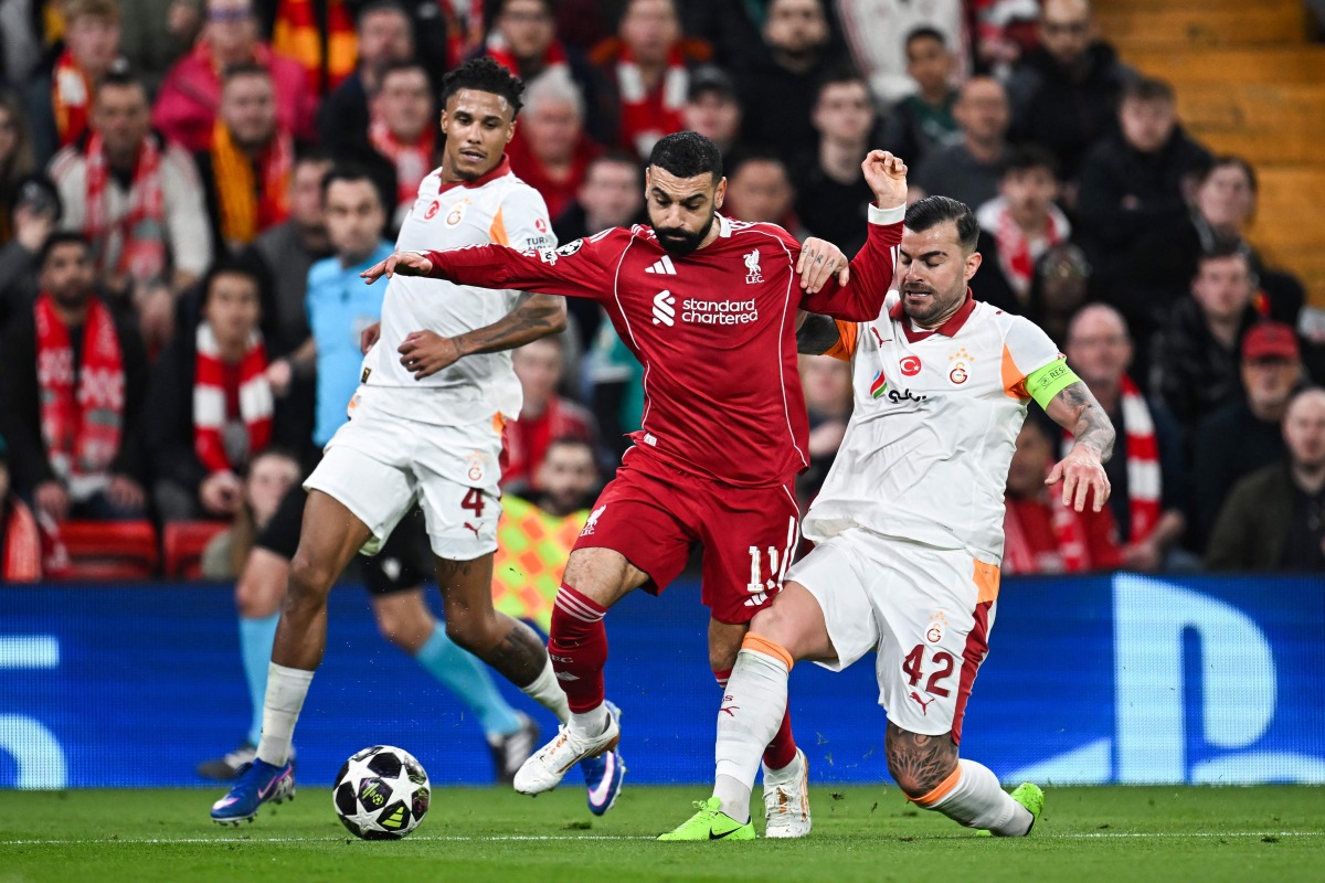 Liverpool's Egyptian forward #11 Mohamed Salah (C) fights for the ball during the UEFA Champions League, round of 16 second leg football match between Liverpool and Galatasaray on March 18, 2026. (Photo by Paul ELLIS / AFP)