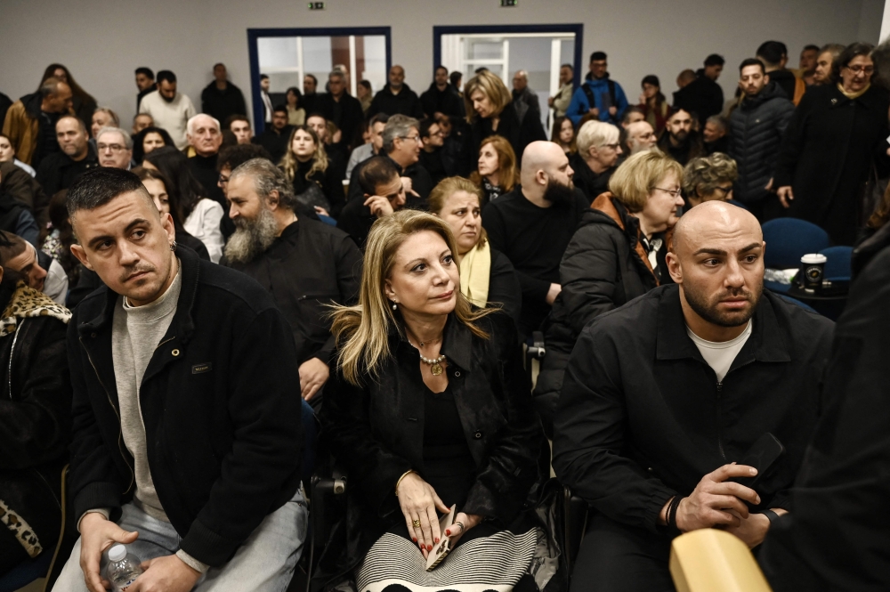 Tempi 2023 Victims' Association president Maria Karystianou (C) sits with relatives inside the 
