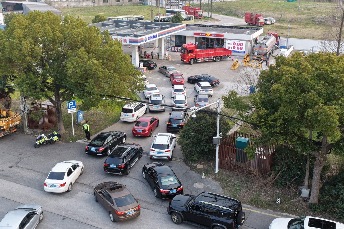 Motorists queue to fill their tanks ahead of a petrol price adjustment expected on March 23, at a petrol station in Suzhou, in China痴 eastern Jiangsu province on March 22, 2026. (Photo by CN-STR / AFP) / China OUT