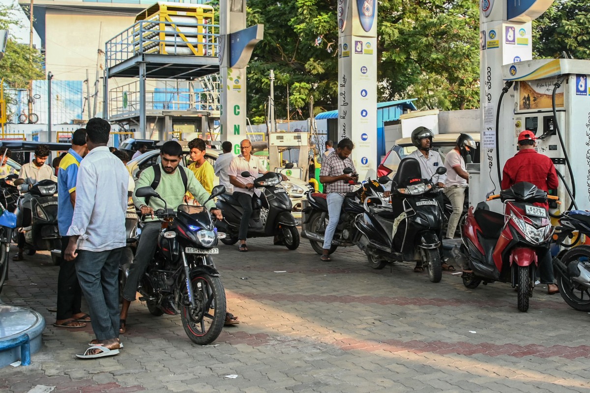 People queue to refuel at a petrol station in Hyderabad on March 25, 2026. Photo by NOAH SEELAM / AFP