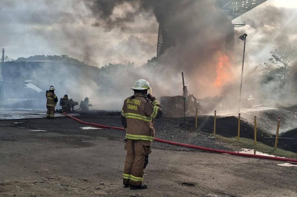 This handout picture released by the Panama Firefighting Department press office shows Panamanian firefighters tackling a blaze caused by the explosion of a fuel tanker under the Bridge of the Americas, at the Pacific entrance to the Panama Canal, in Panama City on April 6, 2026. (Photo by Handout / Panama Firefighting Department / AFP) 