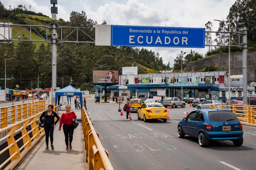 (Files) Vehicles and people cross the Rumichaca International Bridge on the Colombia-Ecuador border, in Ipiales, Narino department, Colombia, on January 21, 2026. (Photo by Reicarmyr Canizares / AFP)