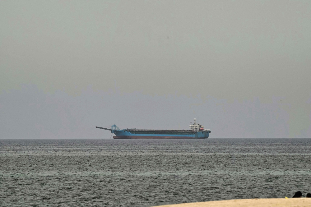 A ship is seen off the coast of Sharjah, the day after the failure of US-Iran peace talks on April 13, 2026. (Photo by AFP)