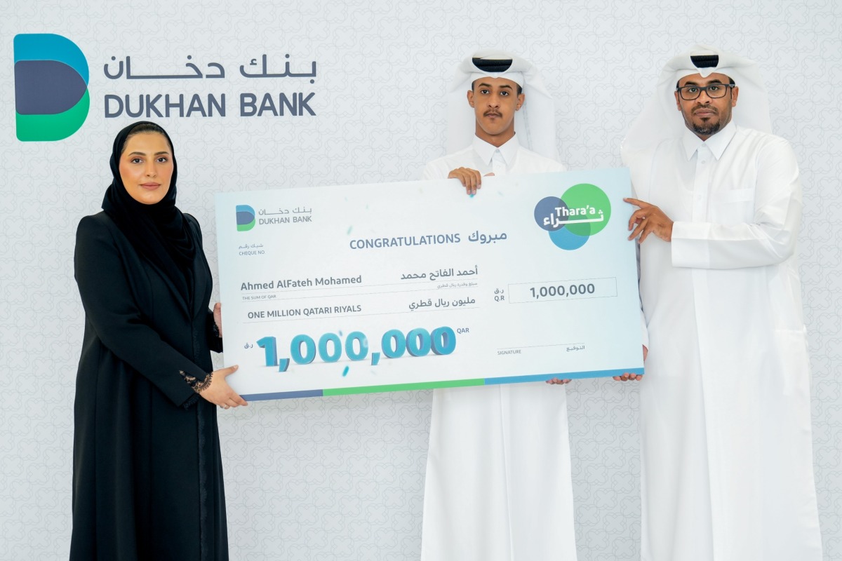 A Dukhan Bank official with the winner of the Thara'a campaign.