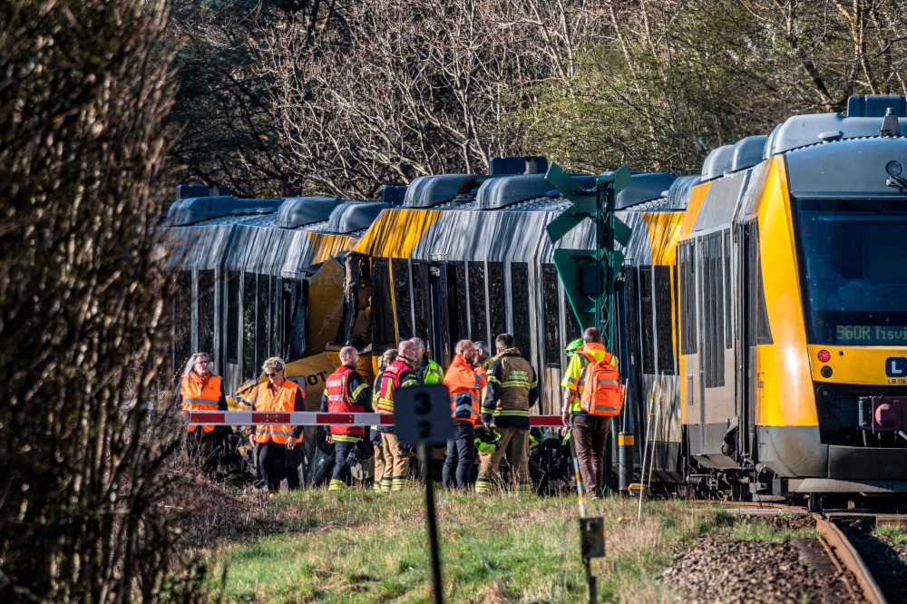 DENMARK-TRANSPORT-RAILWAY-ACCIDENT
Rescue workers stand near two trains that collided between the towns of Hillerod and Kagerup, north of Copenhagen, leaving many injured, on April 23, 2026. The accident happened between the towns of Hillerod and Kagerup, about 40 kilometers (25 miles) from Copenhagen. 
(Photo by Steven Knap / Ritzau Scanpix / AFP) / Denmark 