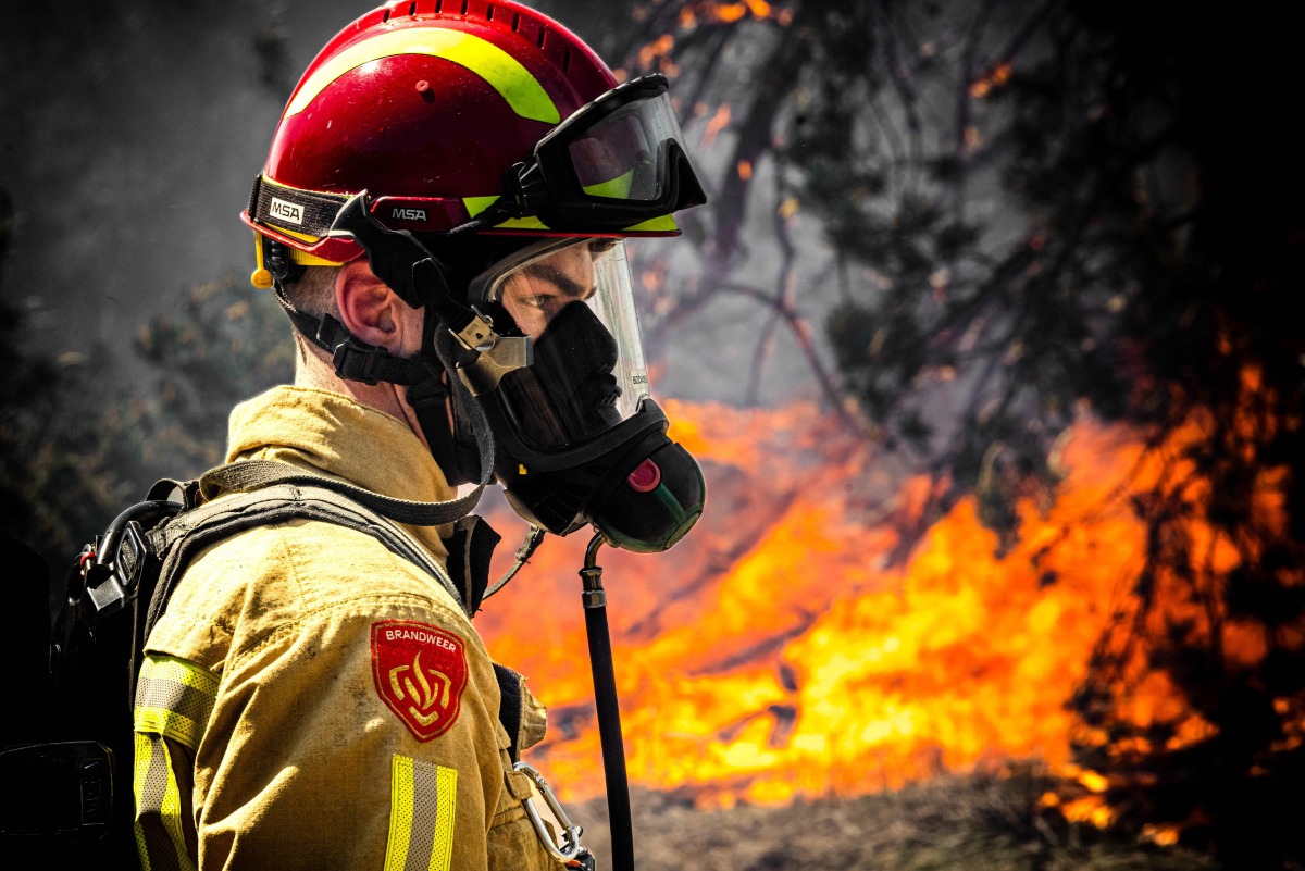 A firefighter works to extinguish a wildfire near Budel, on May 1, 2026 a day after it broke out at a military training ground where a military exercise was taking place. (Photo by ROB ENGELAAR / ANP / AFP)
