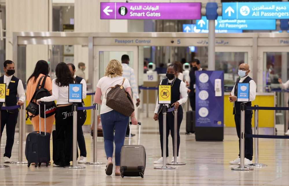 (FILES) A picture shows passengers walking towards the gates at terminal 3 at Dubai international Airport, in the Gulf emirate of Dubai, on August 16, 2022.
(Photo by Giuseppe Cacace / AFP)