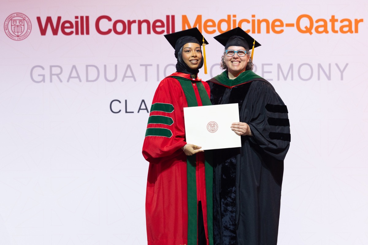 Dr. Moune Jabre presents class valedictorian Dr. Lina Ahmed with her diploma. 