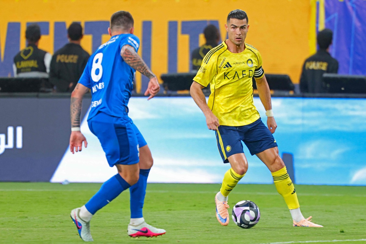 Nassr's Portuguese forward #07 Cristiano Ronaldo fights for the ball with with Al Hilal's Portuguese midfielder #08 Ruben Neves during the Saudi Pro League football match between Al-Nassr and Al-Hilal at King Fahd Sports City Stadium in Riyadh on May 12, 2026. (Photo by Fayez NURELDINE / AFP)