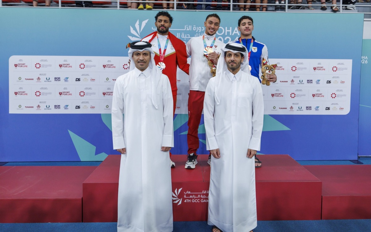 Secretary General of the Qatar Olympic Committee and Vice Chairman of the Organising Committee of the Games Jassim bin Rashid Al Buenain with the podium winners of the men’s 200m individual medley, won by Qatar's Mohamed Mahmoud.