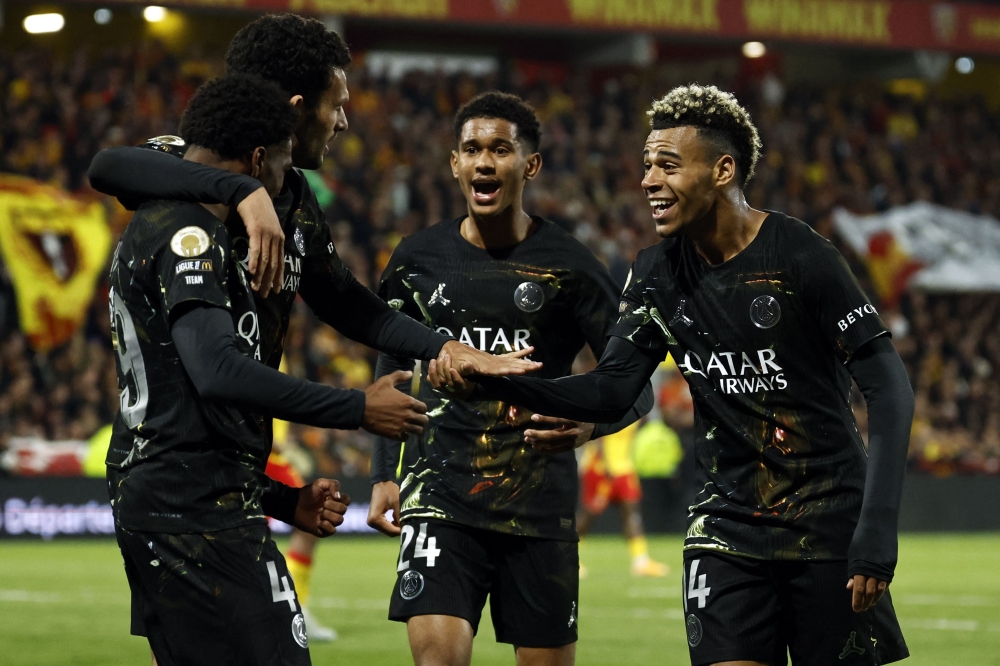 Paris Saint-Germain's French forward #49 Ibrahim Mbaye (L) is congratulated by teammates after scoring a goal during the French L1 football match between RC Lens and Paris Saint-Germain (PSG) at the Stade Bollaert-Delelis stadium in Lens on May 13, 2026. (Photo by SIMON WOHLFAHRT / AFP)
