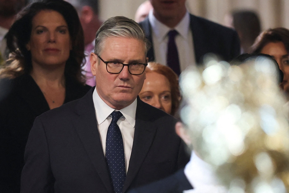 Britain's Prime Minister Keir Starmer (C) returns to the House of Commons after listening to the king's speech during the State Opening of Parliament at the Palace of Westminster in London on May 13, 2026. (Photo by Toby Melville / Pool / AFP)
