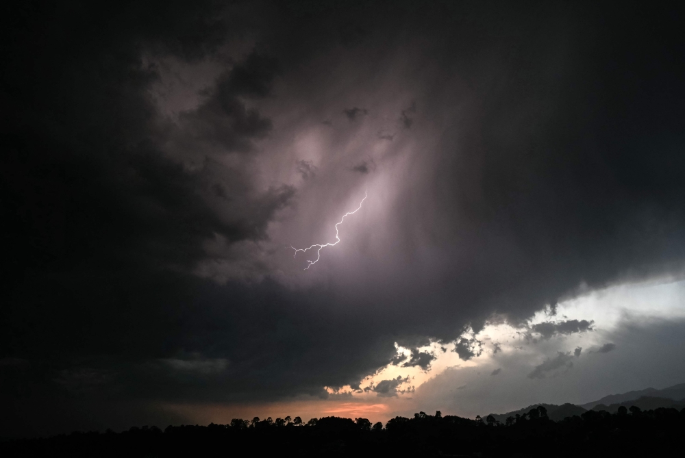 A general view shows the Himalayas' Dhauladhar mountain range as lightning strikes across the sky above Dharamsala on May 13, 2026. (Photo by Sajjad HUSSAIN / AFP)
