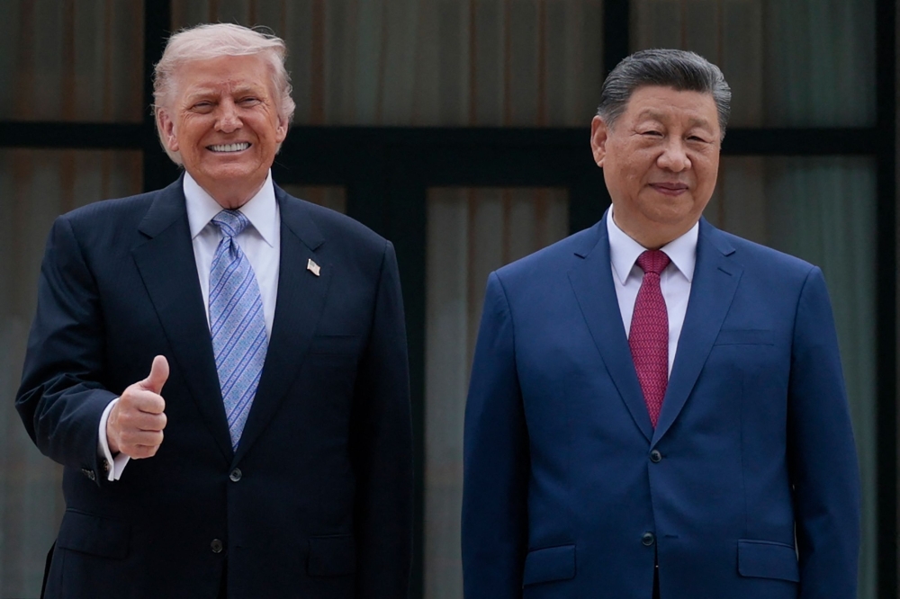 US President Donald Trump (L) poses for photos with China's President Xi Jinping during a visit to Zhongnanhai Garden in Beijing on May 15, 2026. (Photo by Evan Vucci / POOL / AFP)