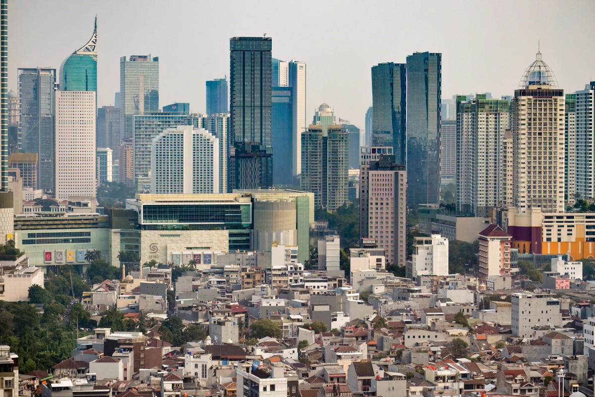 Commercial high-rises buildings are pictured behind low-rise buildings in Jakarta on May 7, 2026. (Photo by BAY ISMOYO / AFP)
