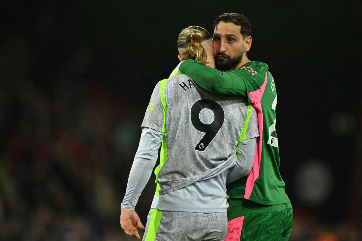 Manchester City's Italian goalkeeper #25 Gianluigi Donnarumma hugs Manchester City's Norwegian striker #09 Erling Haaland after the English Premier League football match between Bournemouth and Manchester City at the Vitality Stadium in Bournemouth, southern England on May 19, 2026. (Photo by Glyn KIRK / AFP)

