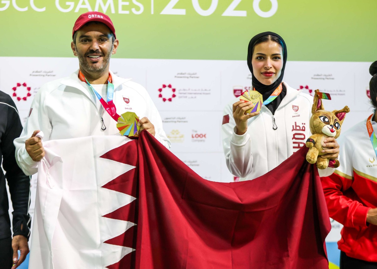 Qatar's Saeed Abu Sharib and Maytha Al-Binali celebrate on the podium after winning the mixed team trap gold. 