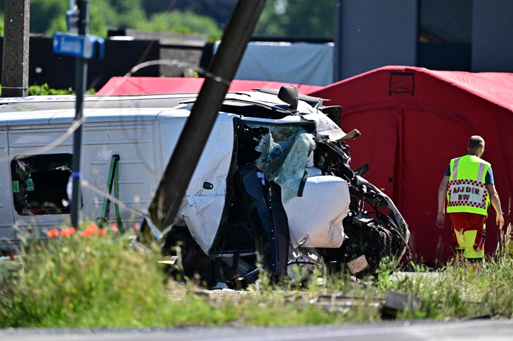 This photograph shows a damaged train car at the site of an accident after a train crashed into a school bus, at the railway crossing Vierhuizen in Buggenhout on May 26, 2026. (Photo by Dirk Waem/ BELGA / AFP)